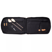 Black chef bag half open panels with compartments containing various kitchen tools on a white background