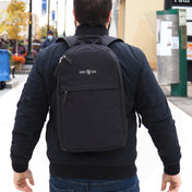 Person wearing a black chef backpack with 'Chef Sac' logo on a city street.