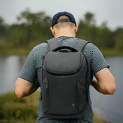 Person wearing a black chef backpack with a blurred natural background
