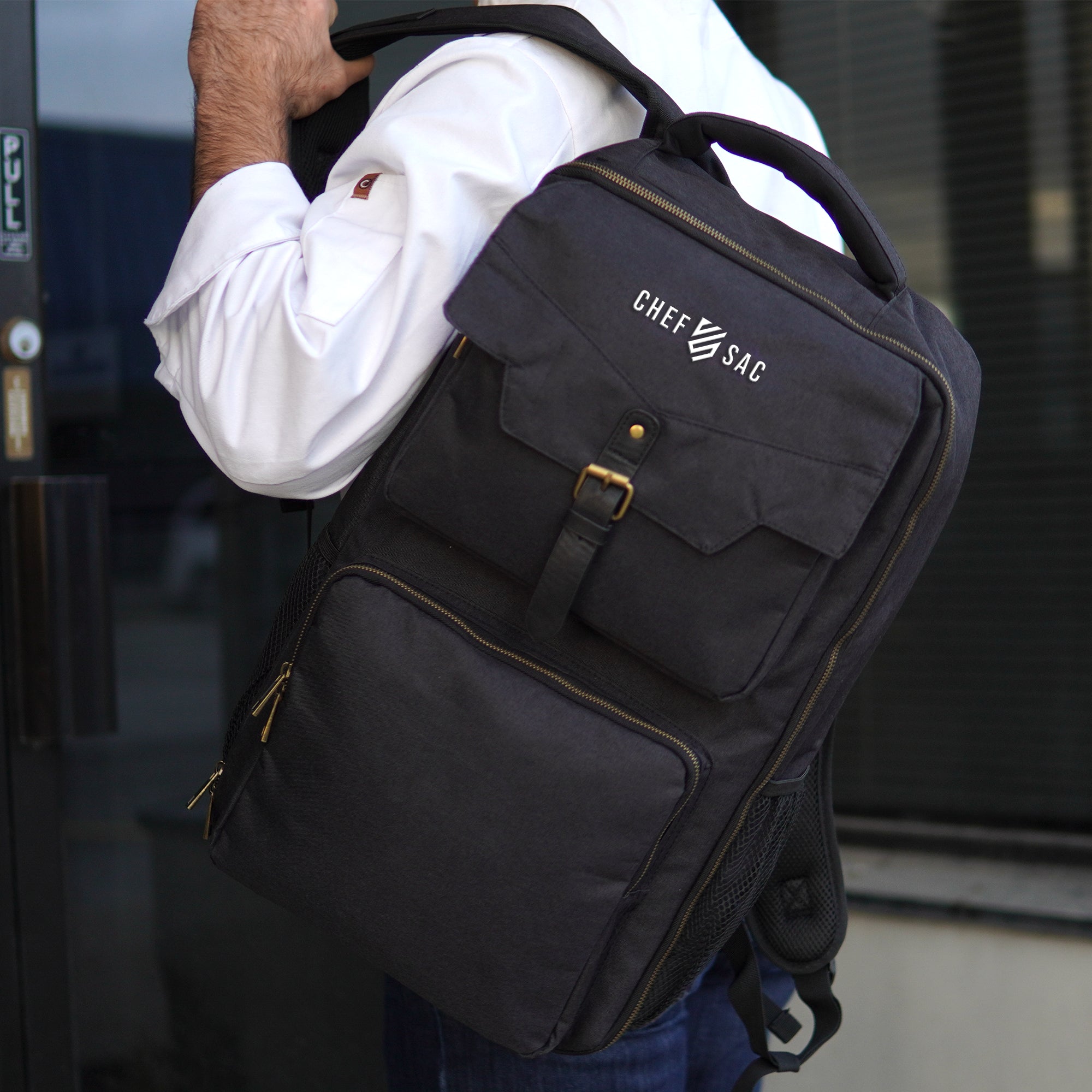Person wearing a black chef backpack with 'Chef Sac' logo, blurred background